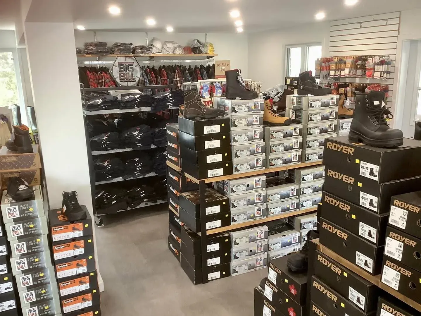 Rayon de bottes de travail du Magasin du Travailleur : tablettes remplies de boîtes de bottes et modèles exposés.